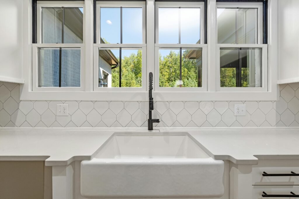 Bright kitchen interior featuring modern sink and large window with outdoor view.