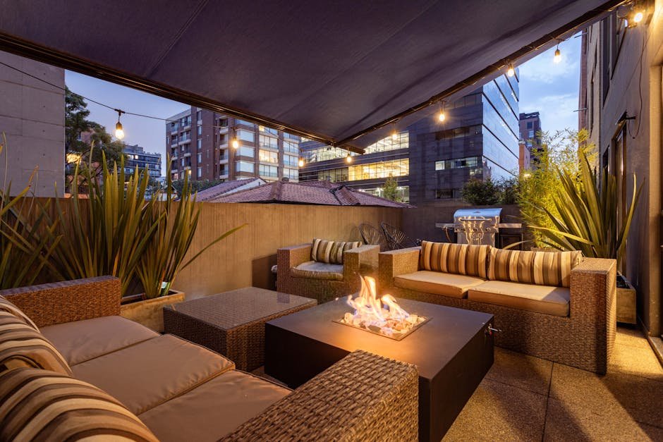 A cozy urban patio setting with elegant furniture and a glowing fire pit during twilight.