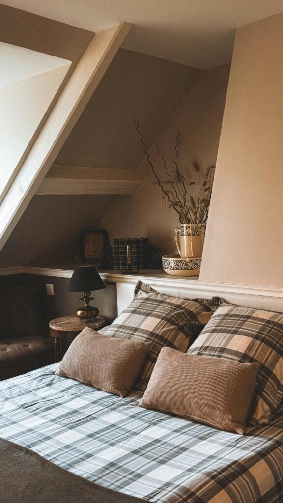 pexels-photo-30439820-30439820 Inviting attic bedroom with boho style decor and plaid bedding in Andorra.