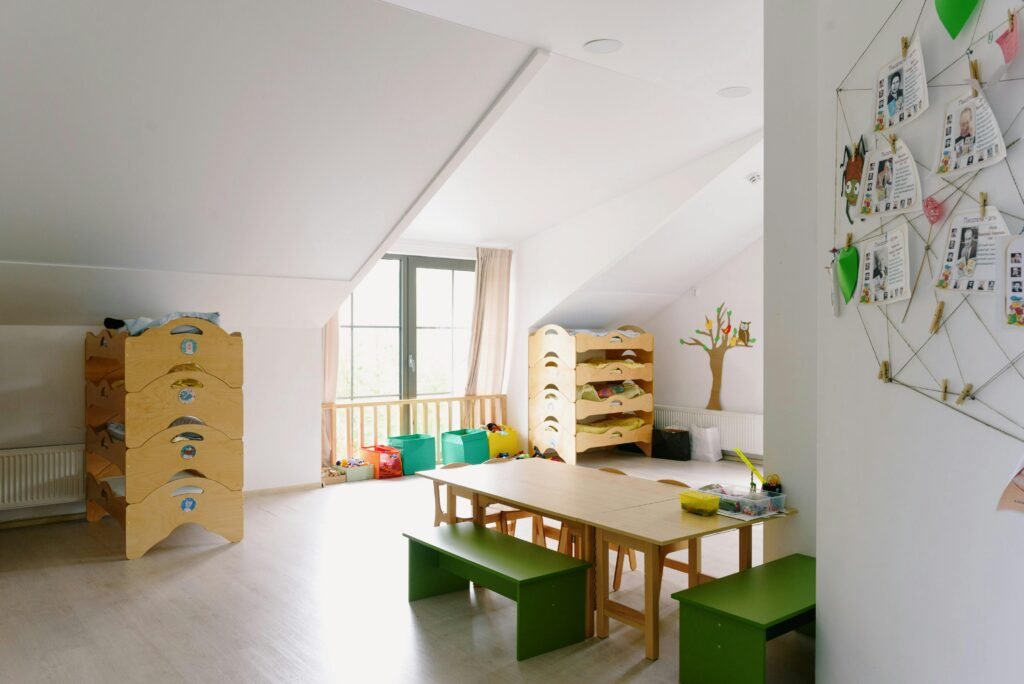 pexels-photo-8535158-8535158 A well-lit and organized kindergarten room with wooden furniture and playful decor.
